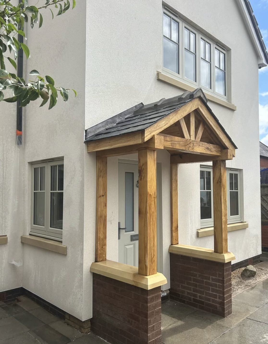 Cream rendered house with an oak framed porch