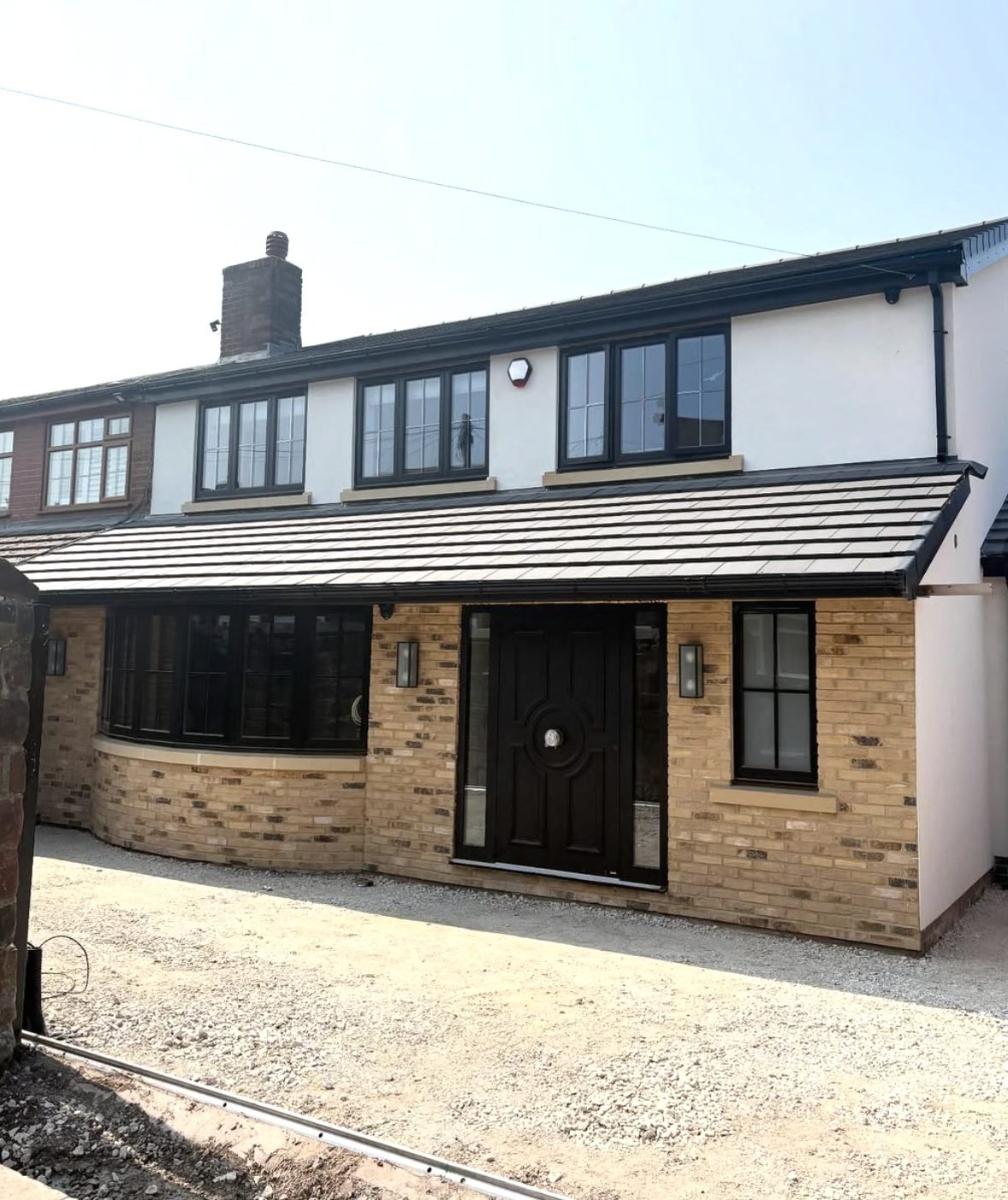 House with white render over a new buff brick front extension