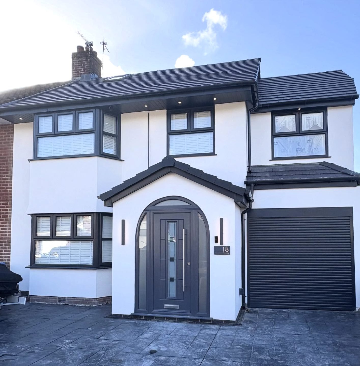 Semi in white render with an arched entrance and a garage