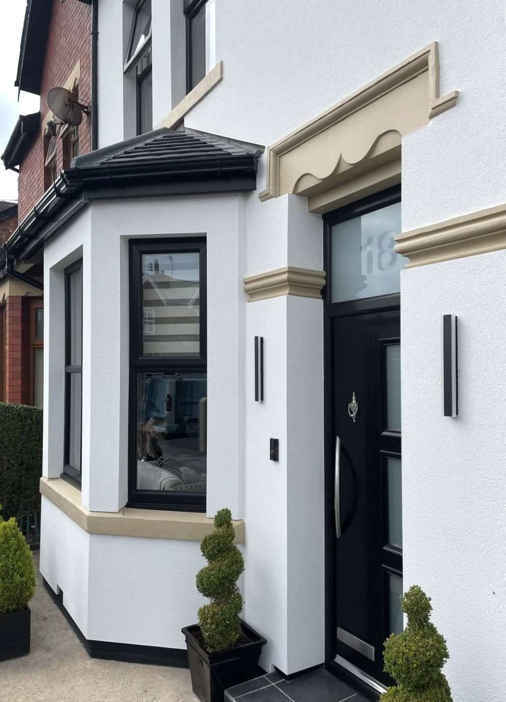 White rendered entrance with a cream door surround and band